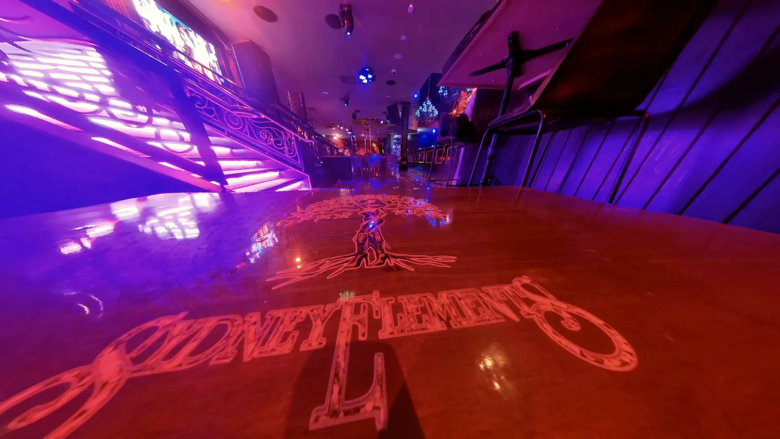 The Sydney Elements tree inlaid on a table at the foot of the lit grand staircase