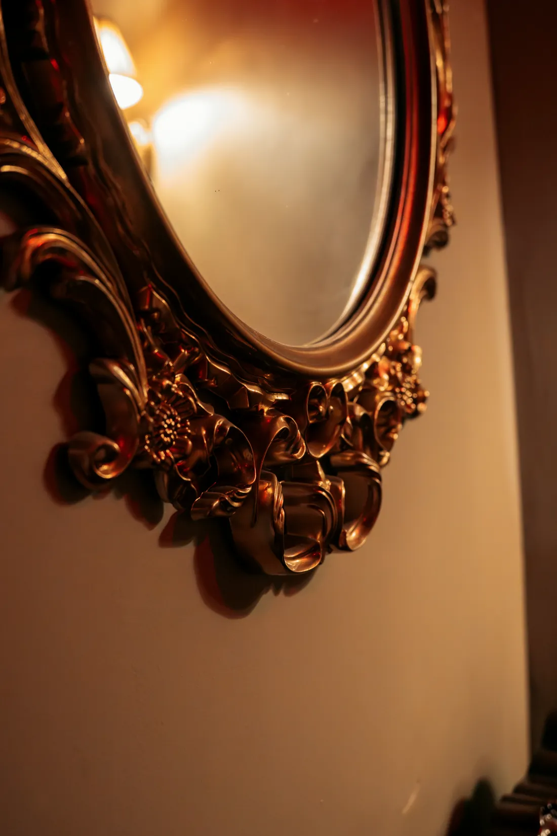 A carved gilt mirror frame in warm light