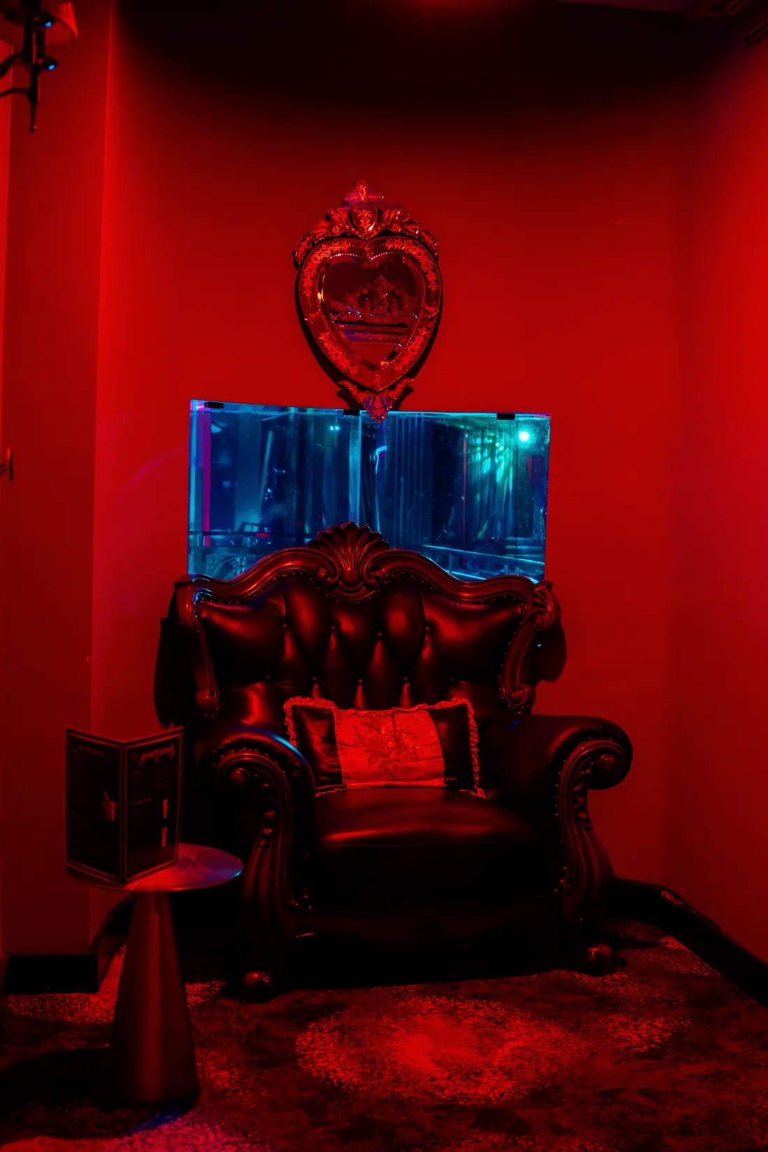 A Venetian heart mirror over a carved leather chair