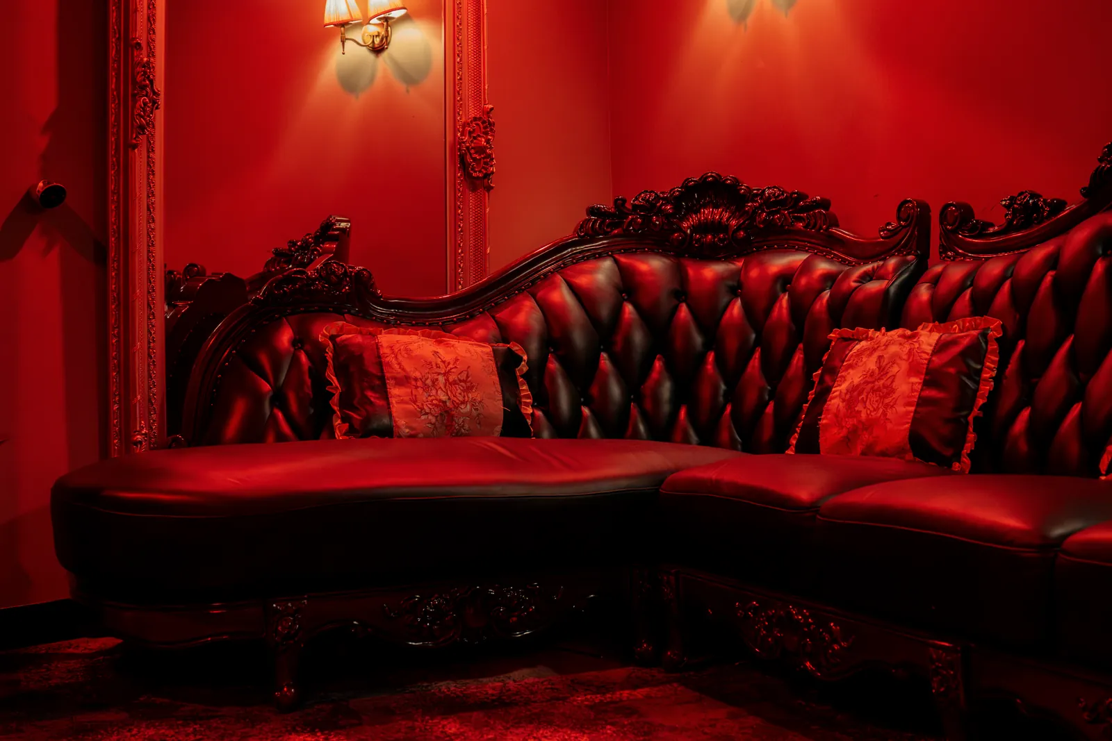 The tufted leather sofa in the red private room