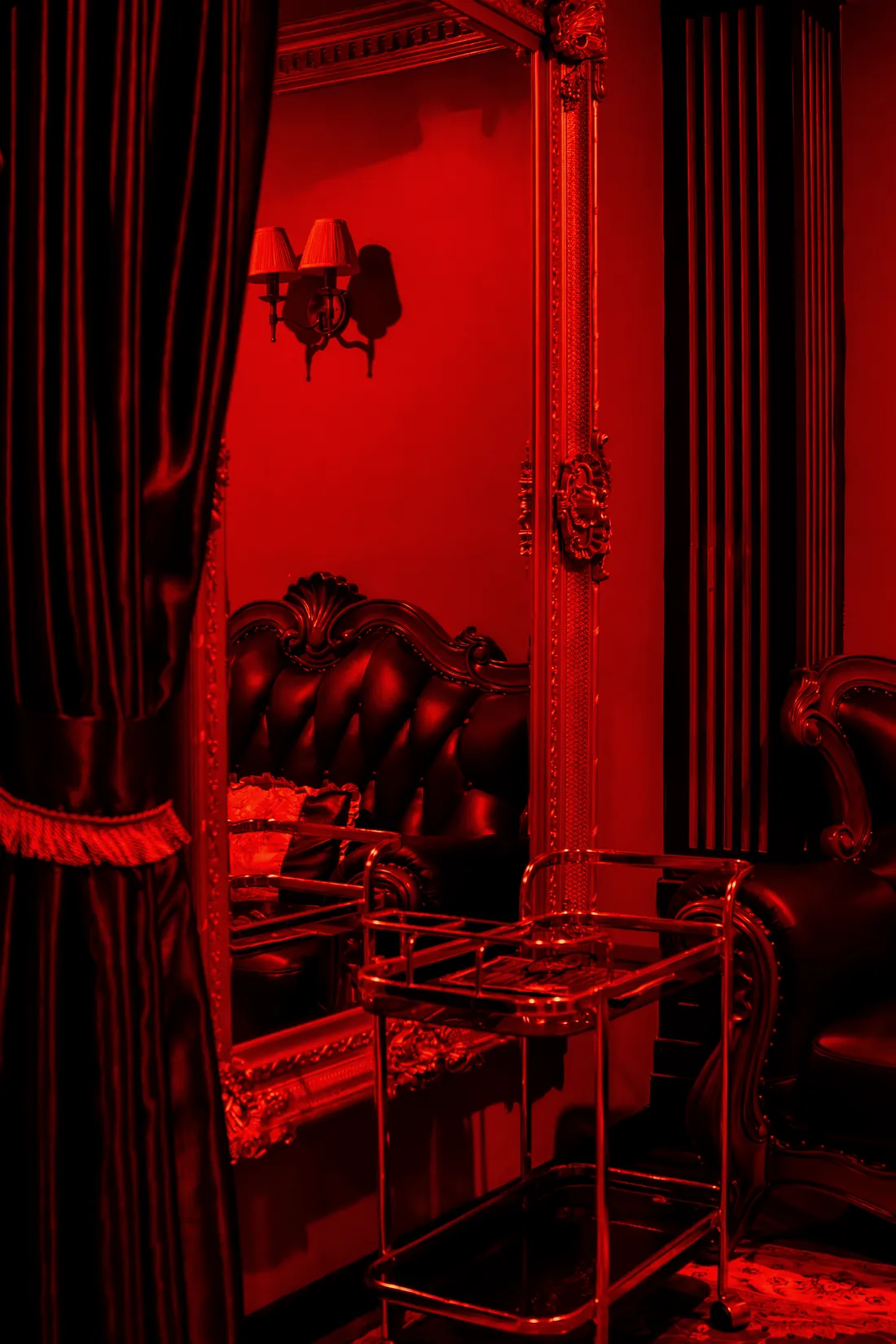 A velvet curtain and gilt mirror in the main private room upstairs