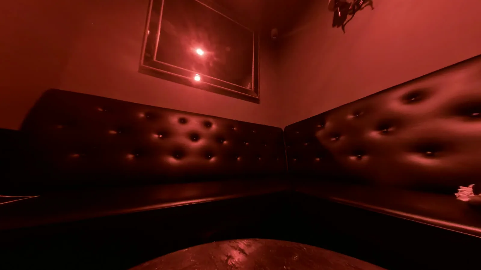 The tufted L-shaped lounge and mirror in VIP Room 2