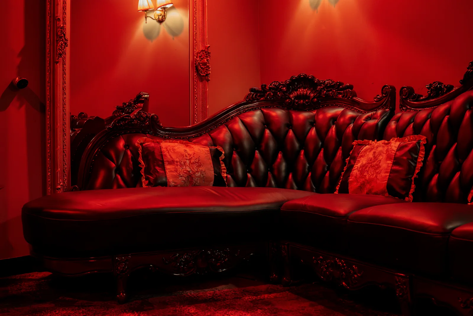 The carved chesterfield and gilt mirror in the largest private room upstairs